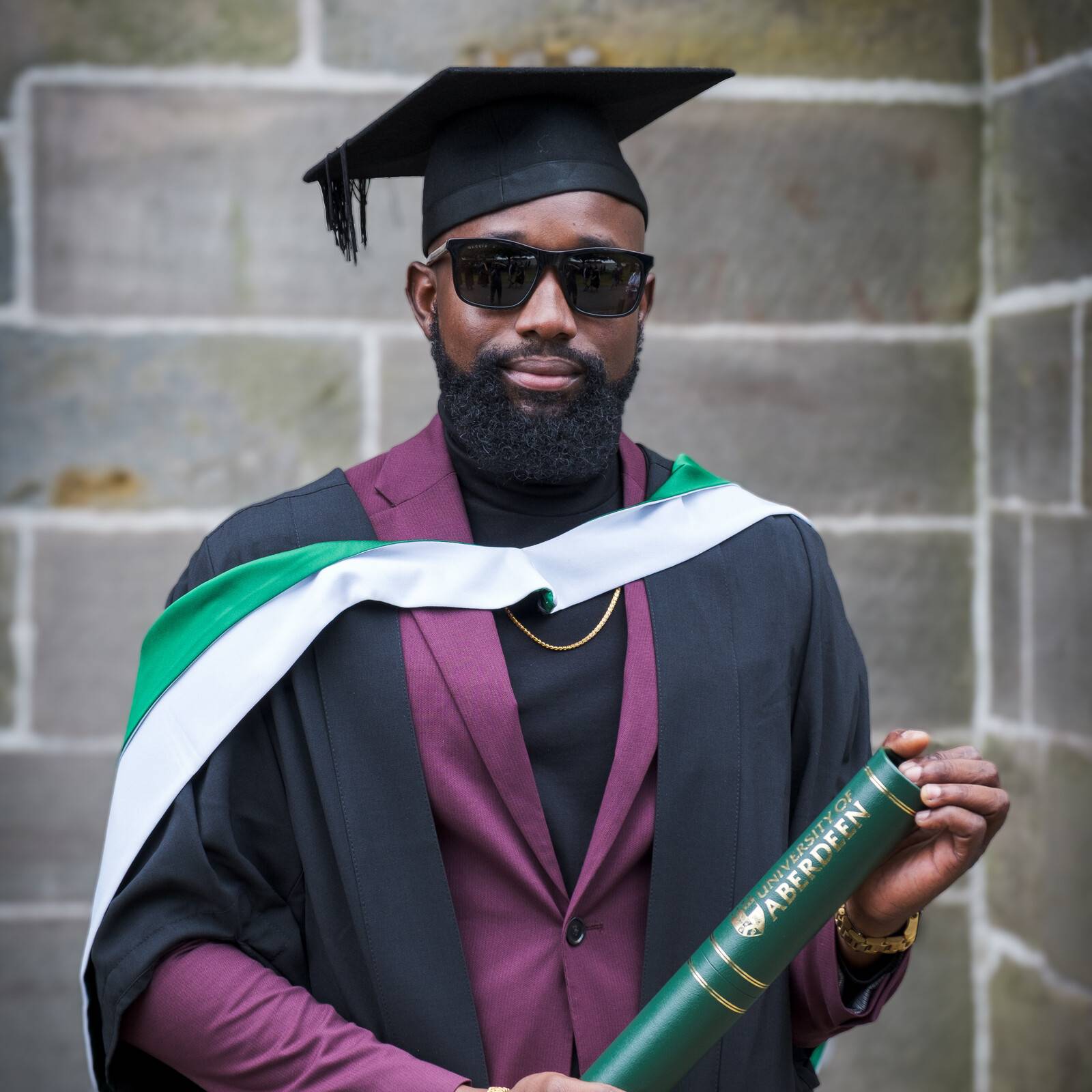 Antoine King in robe, mortar board and sunglasses looks proud and confident at his Aberdeen graduation 