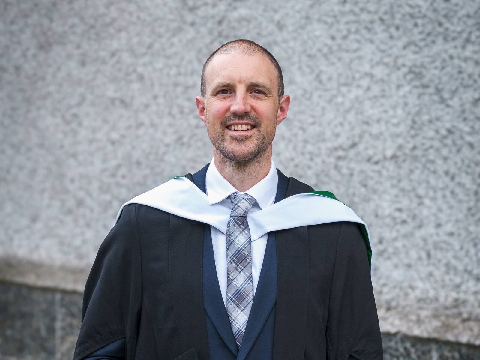 Online student Ben Hull-Bailey smiling at his on-campus graduation ceremony in Aberdeen